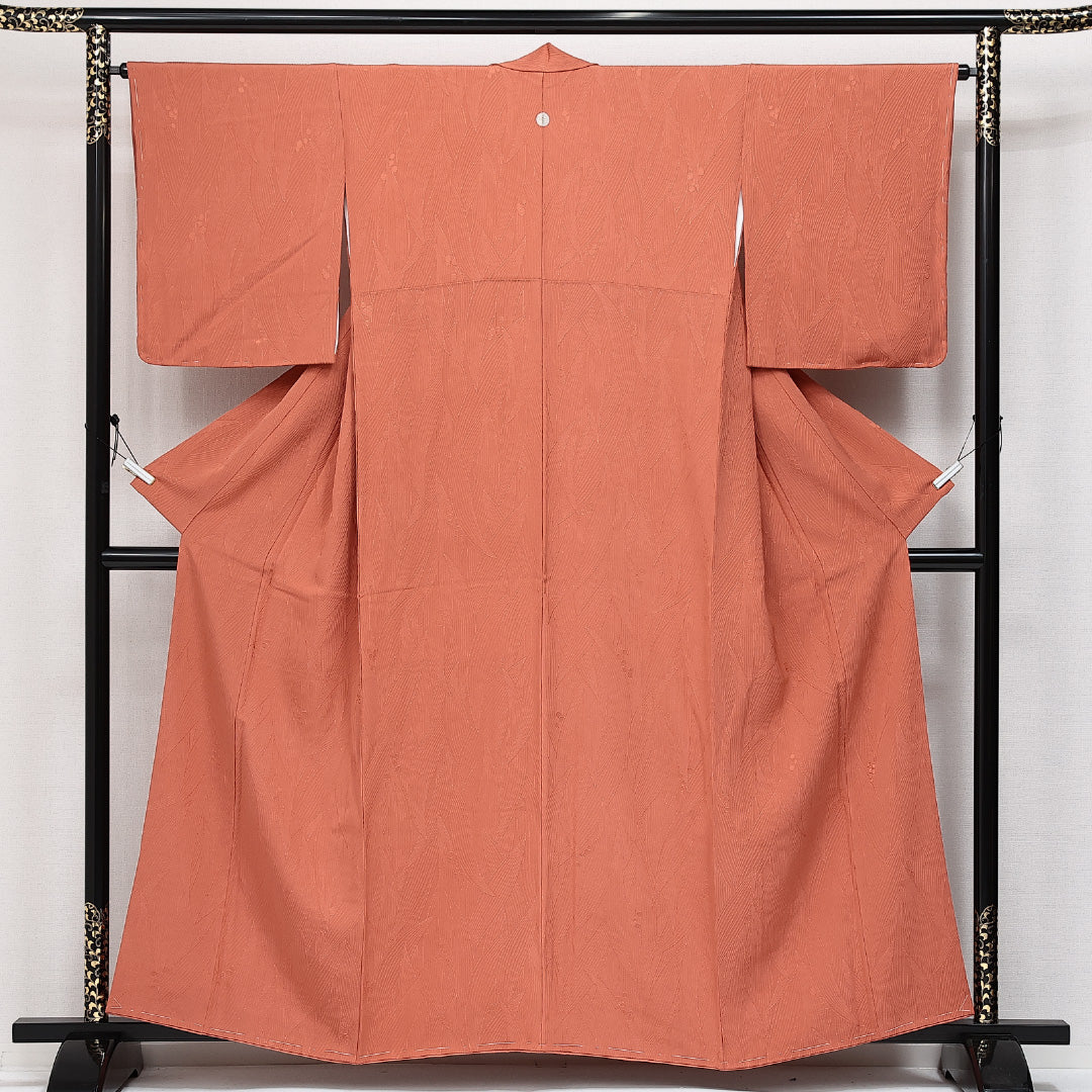 未使用品 色無地 袷 身丈156cm 裄丈64cm 正絹 Nランク 一つ紋 (向かい蝶) 紋意匠 (植物柄) セミフォーマル 広衿 Mサイズ しつけ糸 朱系 M4 1219-14211