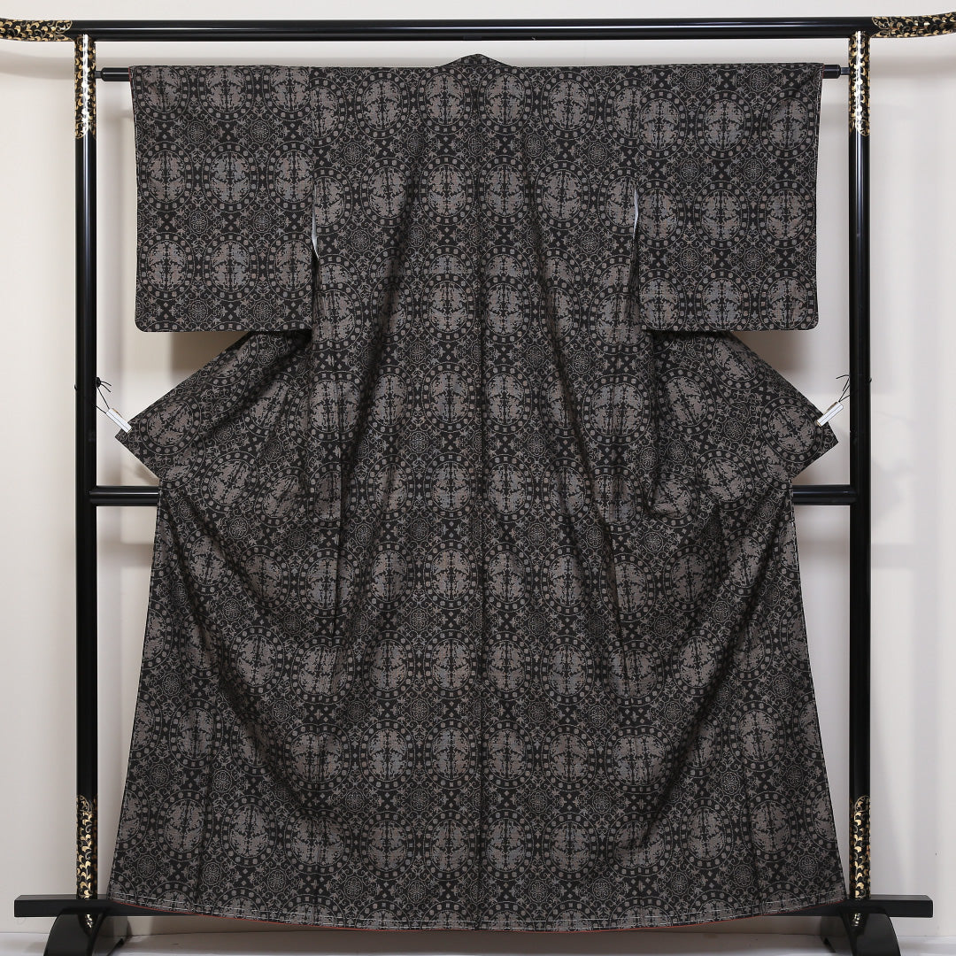 未使用品 紬(大島紬) 袷 身丈160cm 裄丈62cm 正絹 Sランク Lサイズ 広衿 インフォーマル 経緯絣 連珠文 しつけ糸 黒系 1216-03133