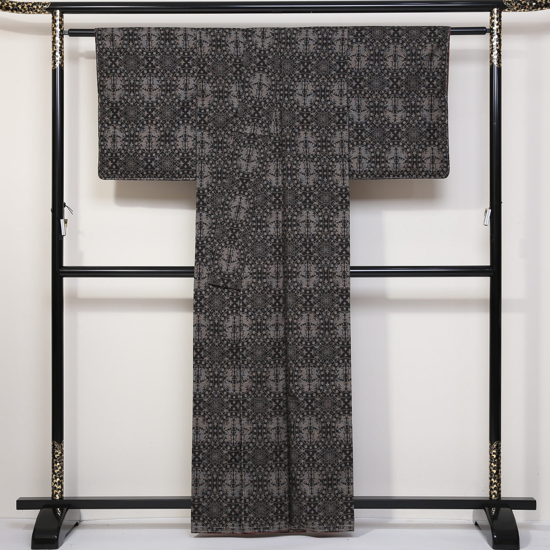 未使用品 紬(大島紬) 袷 身丈160cm 裄丈62cm 正絹 Sランク Lサイズ 広衿 インフォーマル 経緯絣 連珠文 しつけ糸 黒系 1216-03133