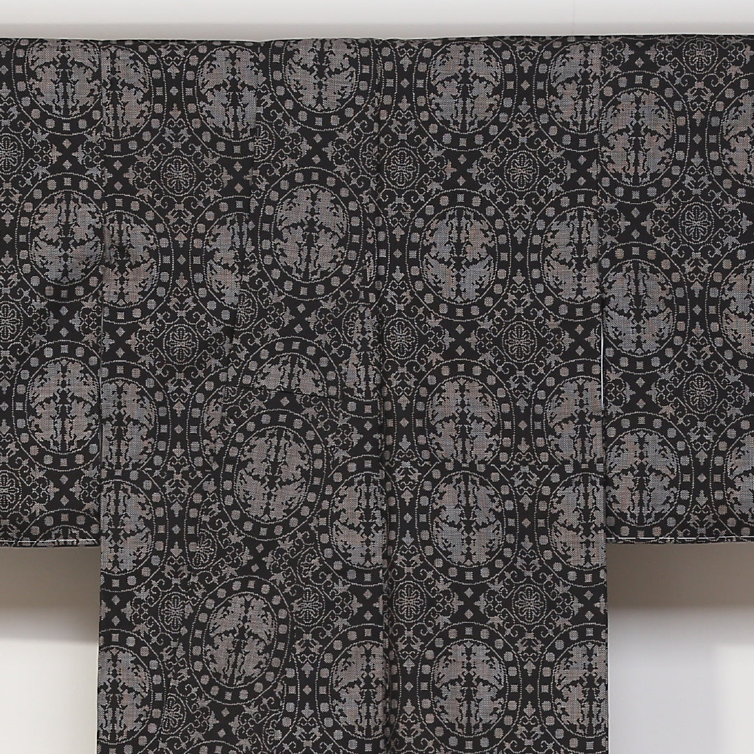 未使用品 紬(大島紬) 袷 身丈160cm 裄丈62cm 正絹 Sランク Lサイズ 広衿 インフォーマル 経緯絣 連珠文 しつけ糸 黒系 1216-03133