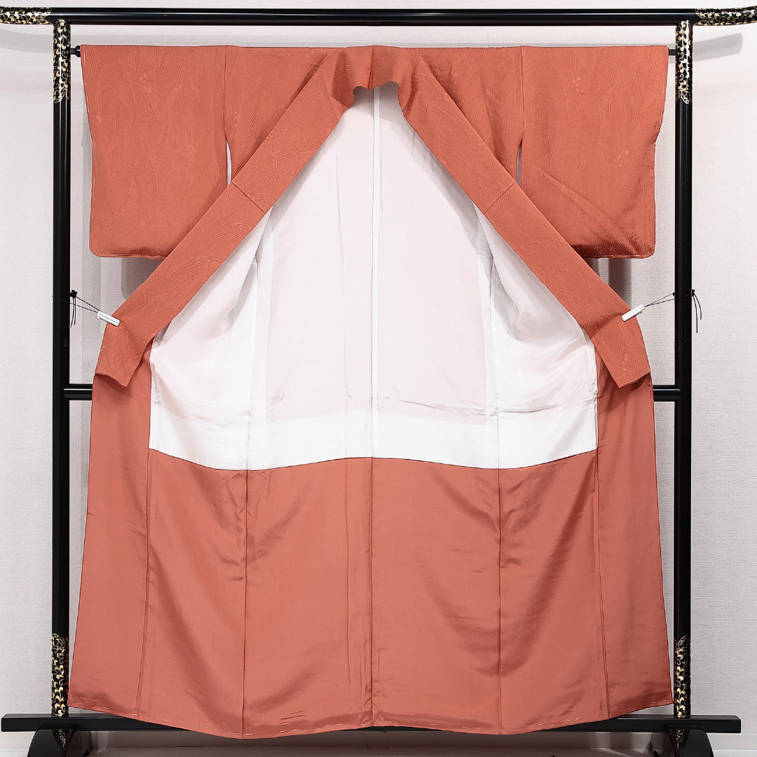 未使用品 色無地 袷 身丈156cm 裄丈64cm 正絹 Nランク 一つ紋 (向かい蝶) 紋意匠 (植物柄) セミフォーマル 広衿 Mサイズ しつけ糸 朱系 M4 1219-14211
