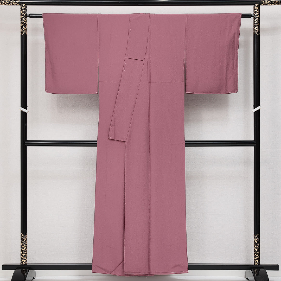 未使用品 色無地 袷 身丈154cm 裄丈62cm 正絹 Sランク 一つ紋 (丸に四つ剣片喰) セミフォーマル 広衿 Sサイズ ふくれ織 しつけ糸 ピンク系 RP 1219-14224