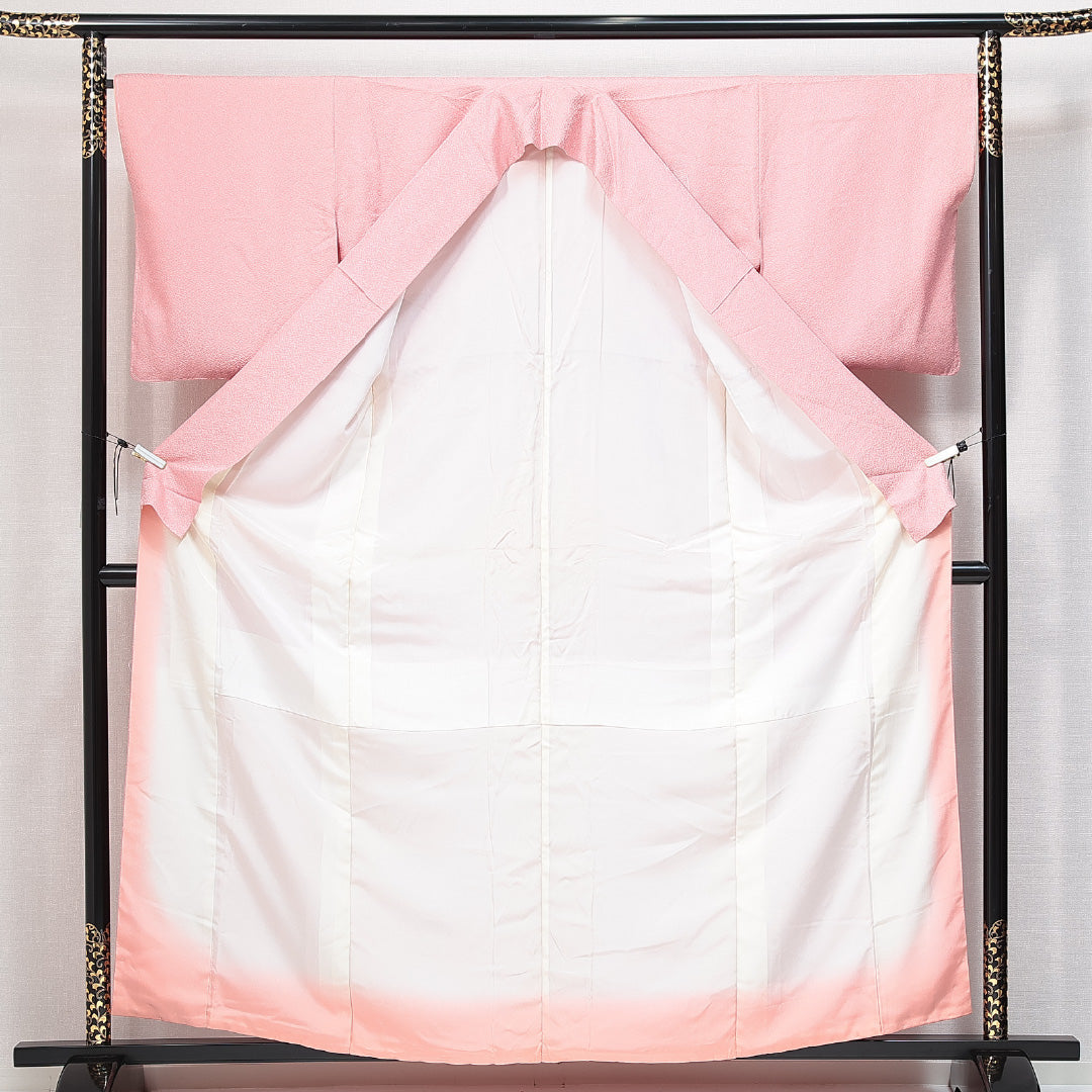 未使用品 色無地 袷 身丈158cm 裄丈65cm 正絹 Nランク 一つ紋 (五三桐) 紋意匠 (紗綾型) セミフォーマル 広衿 Mサイズ 付下げ 蘇州刺繍 汕頭刺繍 しつけ糸 亀甲 牡丹 ピンク系 M4 1219-14737